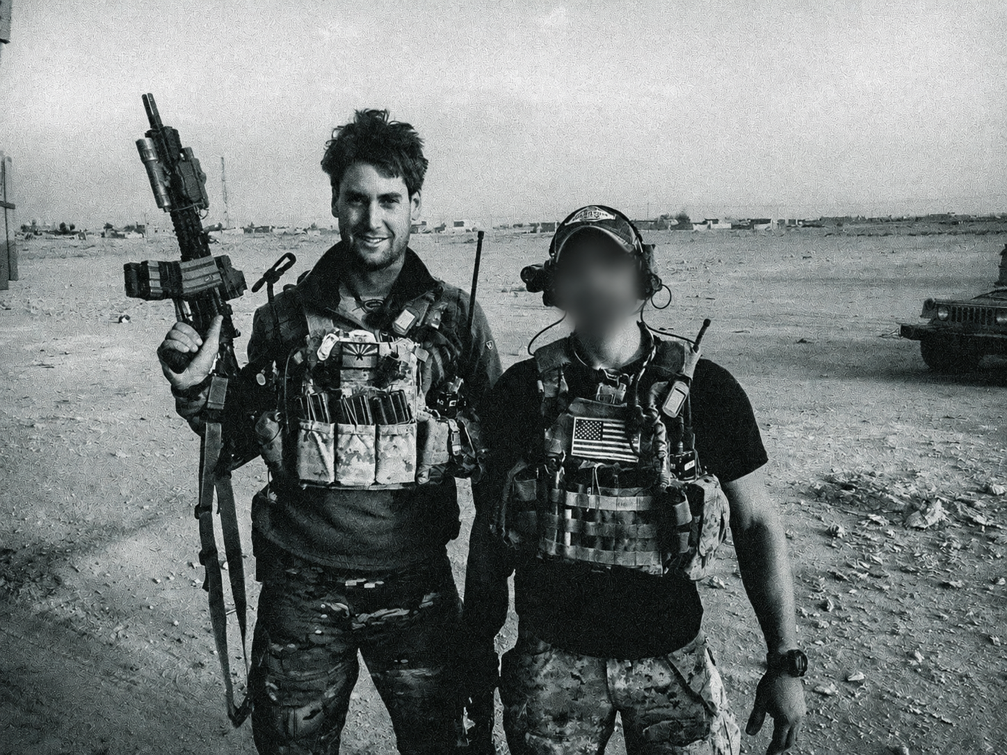 Black-and-white service photograph of two people, with the right person’s face blurred
